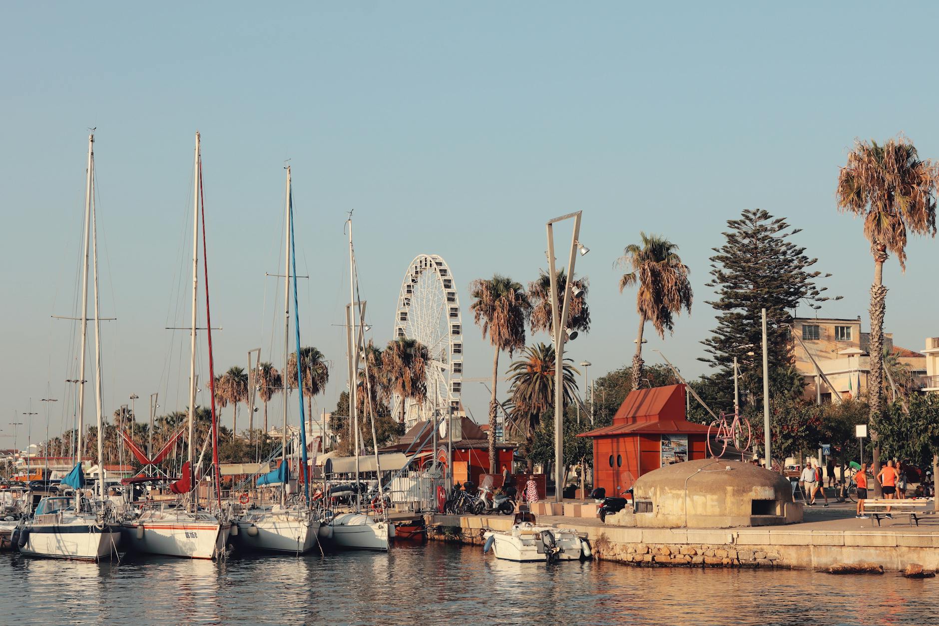 French President Emmanuel Macron aboard the aircraft carrier Charles de Gaulle speaking with naval officers against the ship’s deck backdrop.