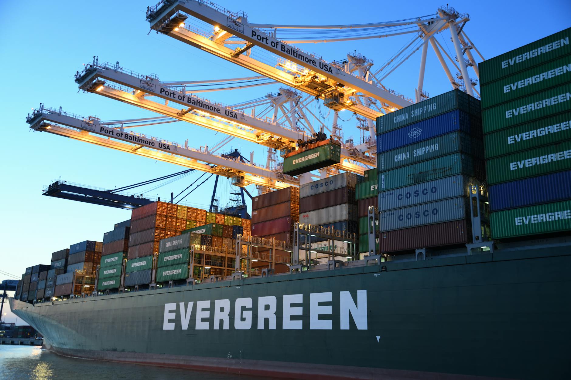 European Union and United States trade negotiators shake hands against flags with shipping containers in background
