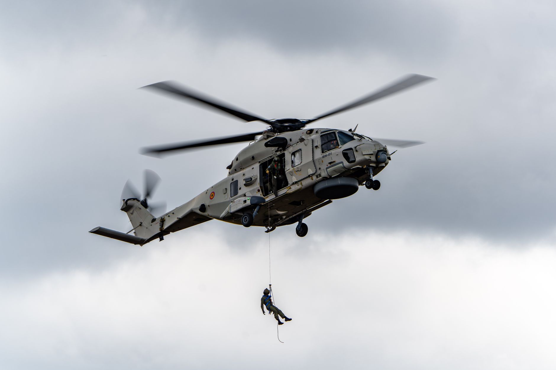 A Danish military helicopter monitors a Russian naval vessel during a surveillance mission over the Baltic Sea.